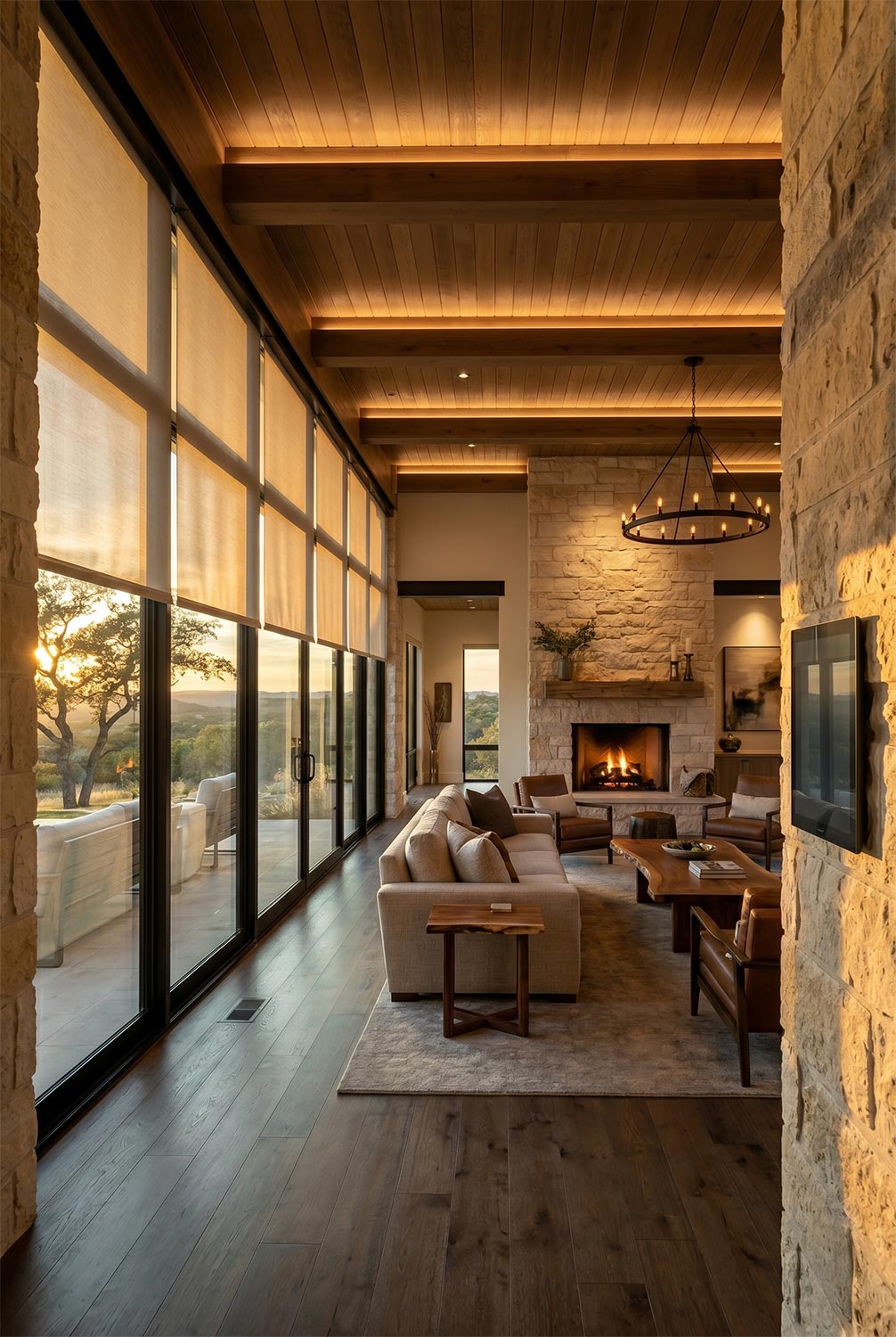 Modern living room with stone fireplace and large windows at dusk
