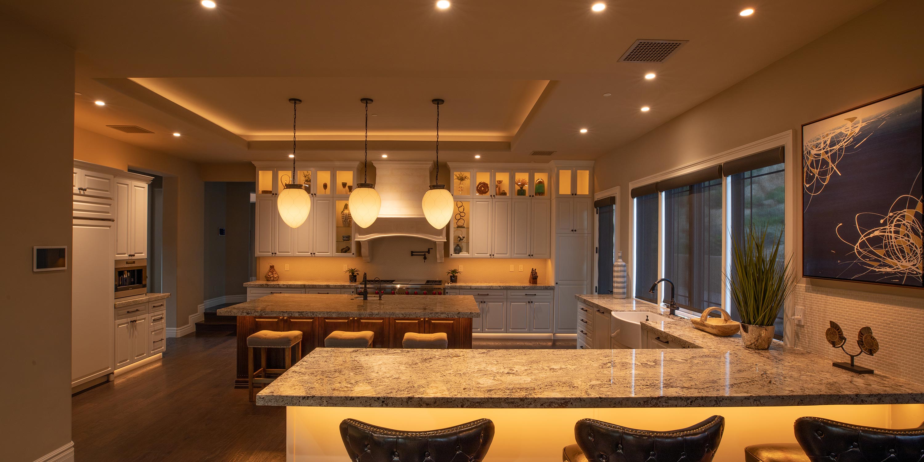 Luxury kitchen with granite countertops pendant lighting and white cabinetry