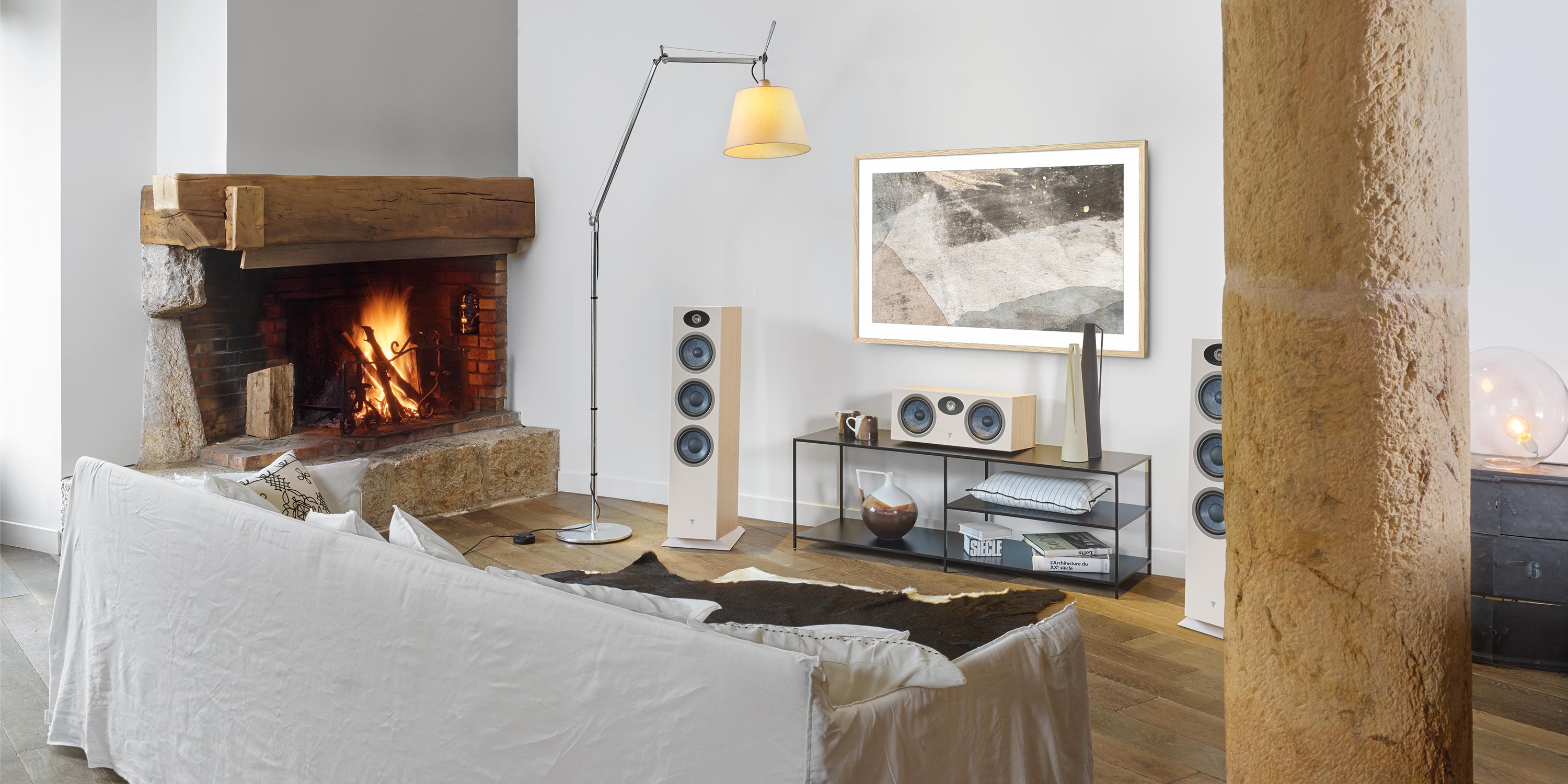 Elegant room featuring high-end speakers a fireplace and a white sofa