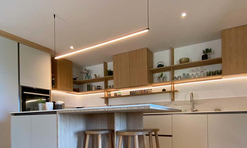 Under-cabinet LED strips illuminating a kitchen countertop