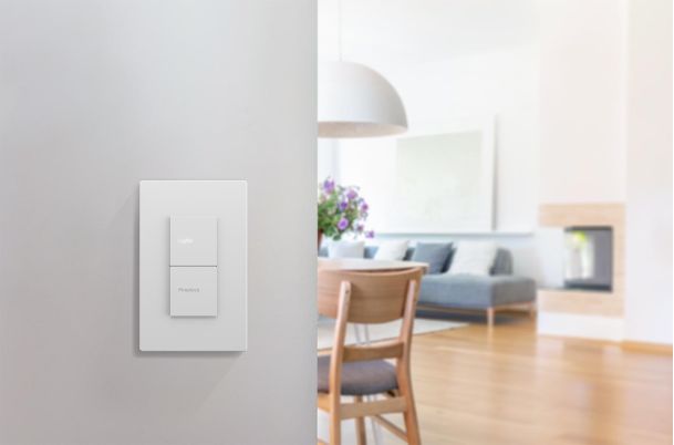 Minimalist white light switch on a wall with a blurred living room background