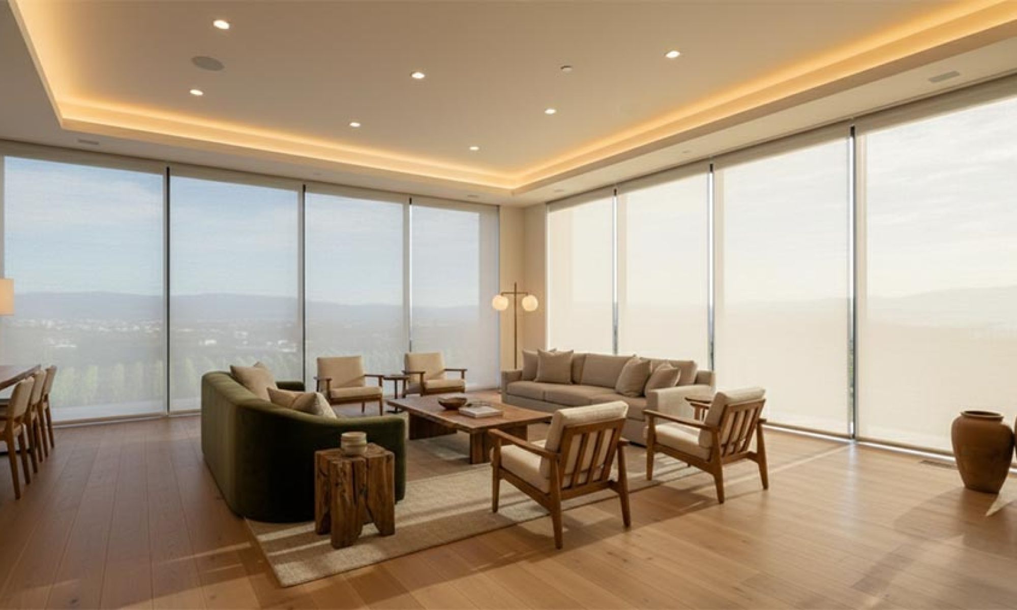 Minimalist living room with large windows, neutral furniture, and warm cove ceiling lighting