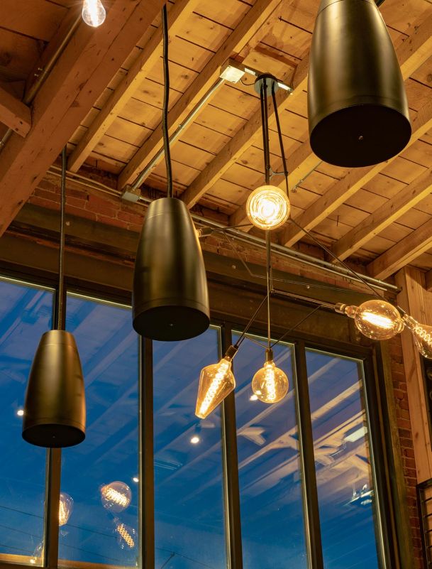 Industrial style pendant lighting with exposed filament bulbs against a wood plank ceiling