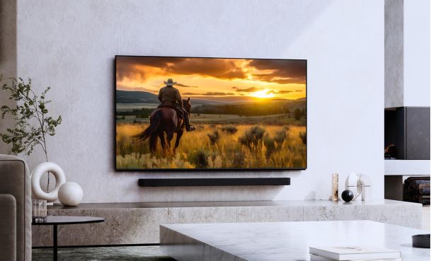 Television displaying a sunset scene with a rider on horseback above a stone console