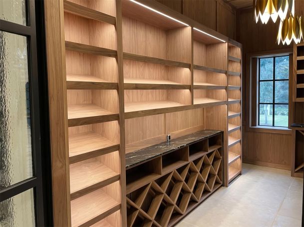 Custom wood shelving unit with integrated LED lighting and built-in diamond grid wine rack