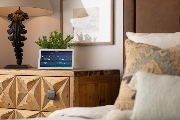 Smart home tablet displaying lighting controls on a carved wooden dresser