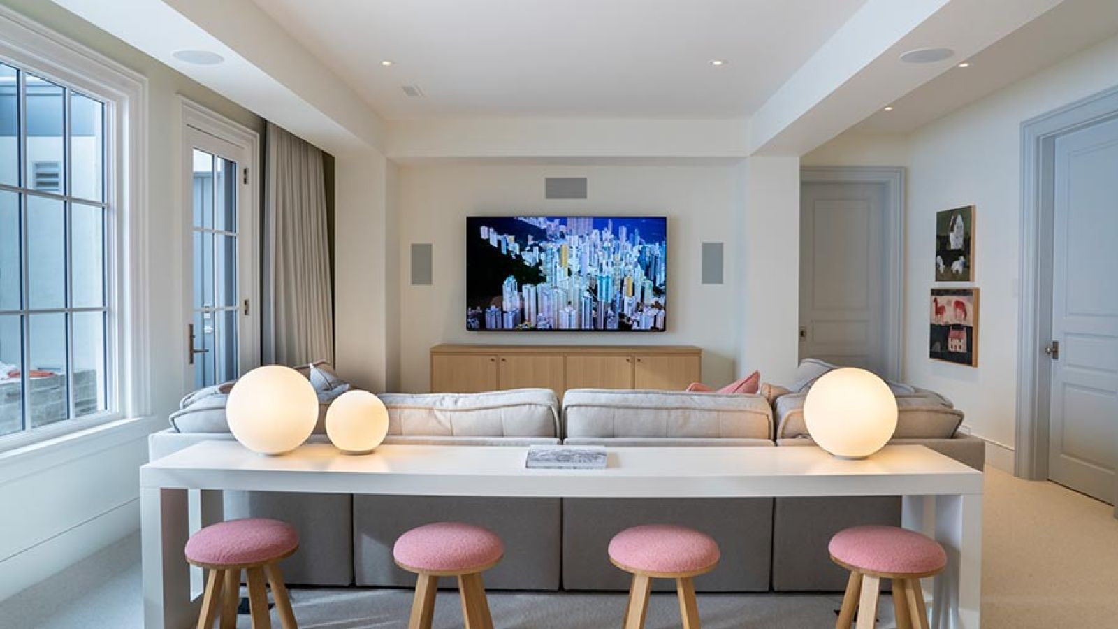 Modern living room with a television, gray sectional sofa, and white console table