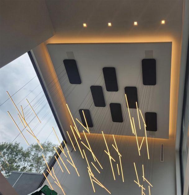 Modern ceiling design with recessed acoustic panels and hanging linear light fixtures