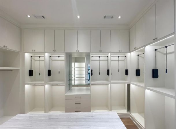 Custom white walk-in closet with integrated LED shelf lighting