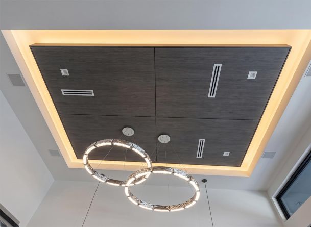 Dark wood inset ceiling feature with cove lighting and interlocking ring chandeliers