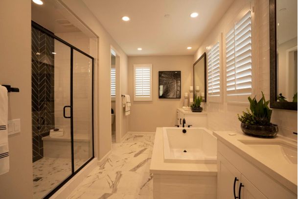 Bright modern bathroom with a glass shower and marble tile flooring