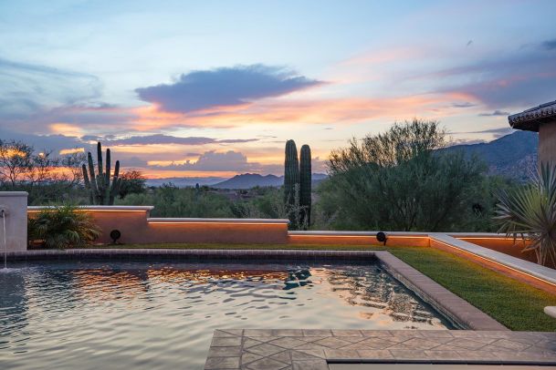 Outdoor pool at sunset with desert landscape and saguaro cacti