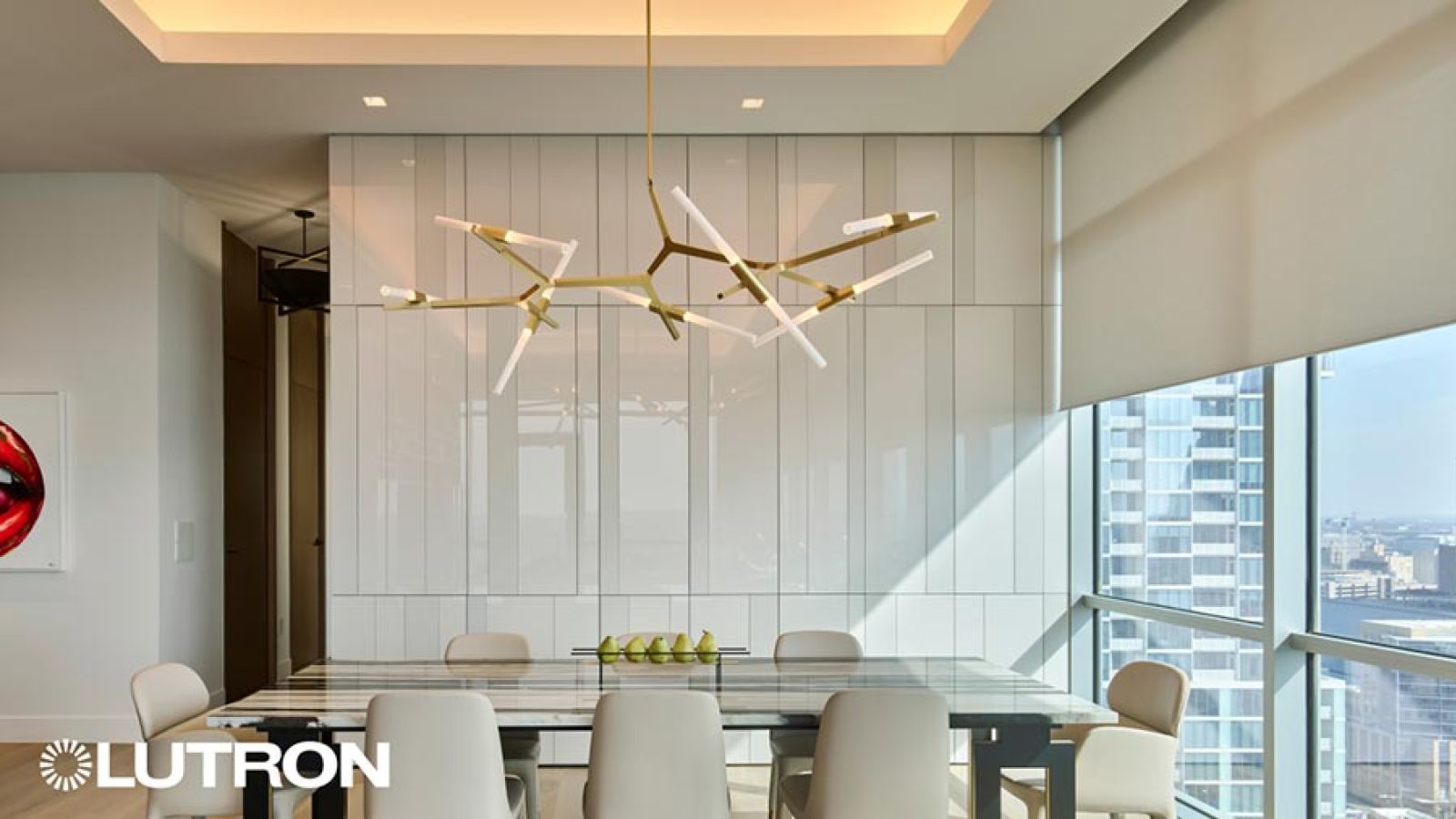 Contemporary dining room featuring a gold branch chandelier and large windows with shades