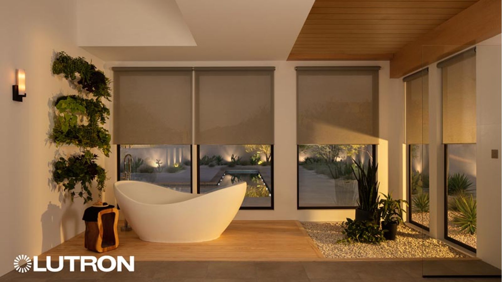 Modern bathroom with a freestanding tub and motorized window shades overlooking a courtyard